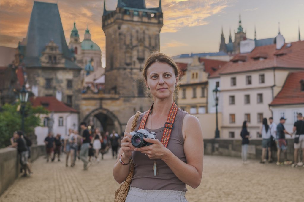 Woman taking pictures of Charles bridge during sunset Prague, Czech Republic - Blue Ribbon Travel